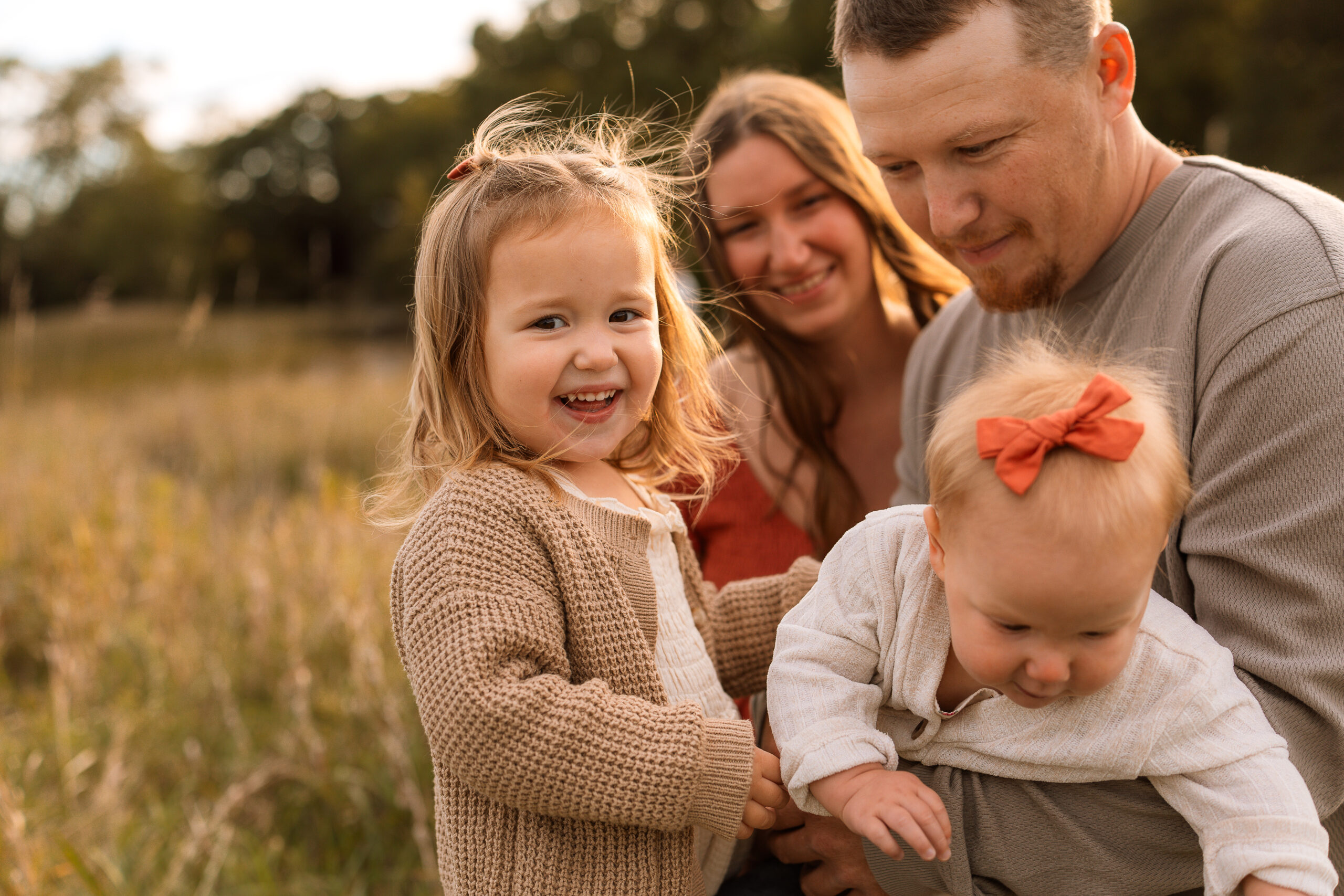 family photo session in delafield Wisconsin family of 4 older daughter looking at camera and laughing