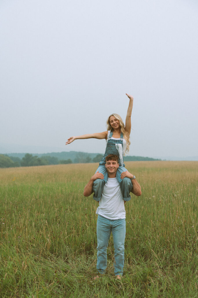Couple laughing together during a Wisconsin couples photoshoot in a grassy field
